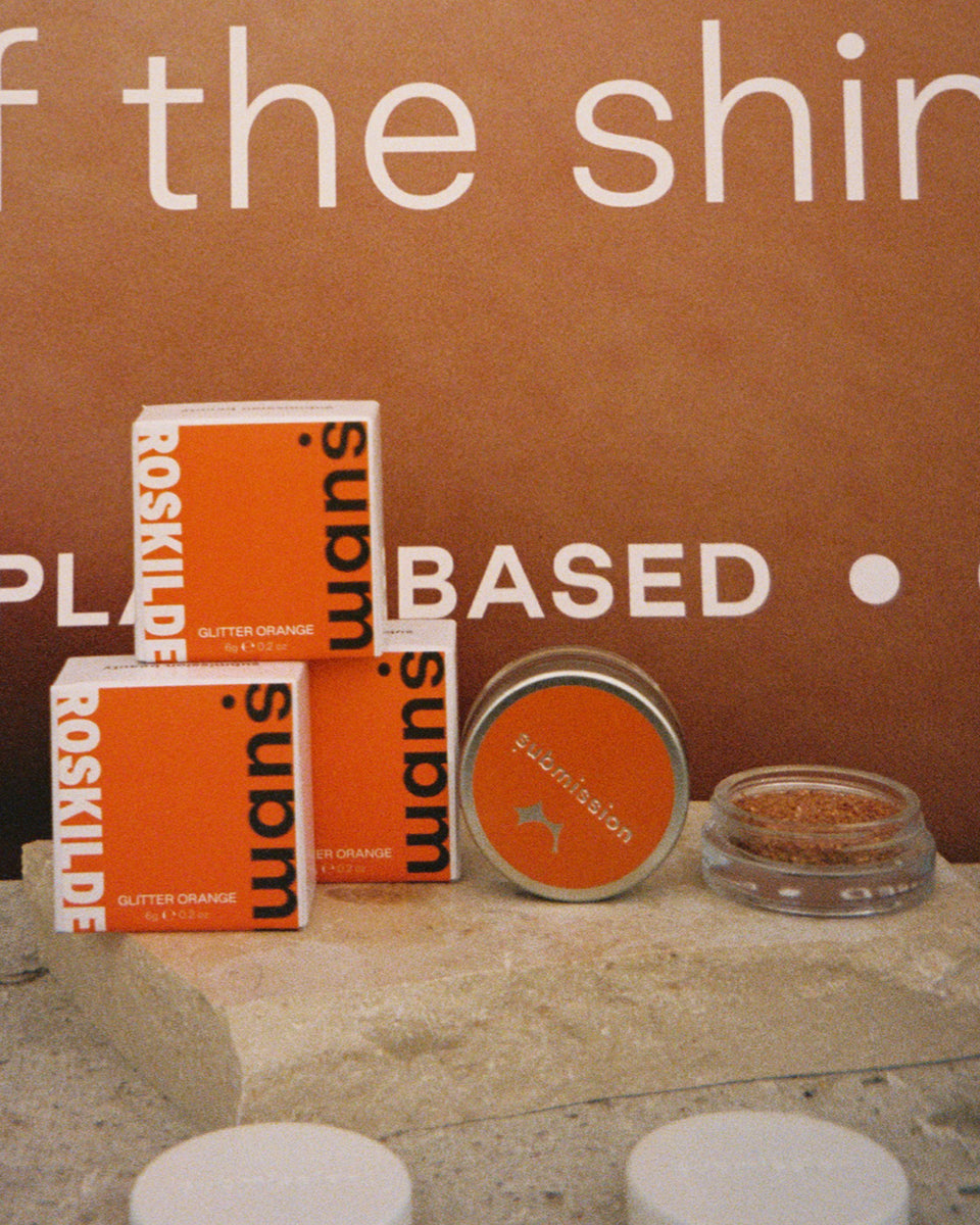 Submission Beauty limited edition glitter with Roskilde Festival with orange packaging on a brown background