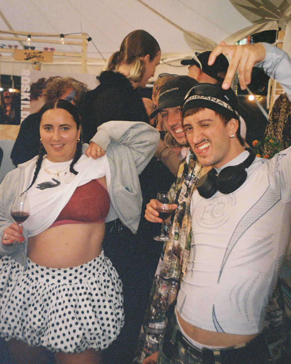 Group of people at a party with one person holding a glass of red wine.