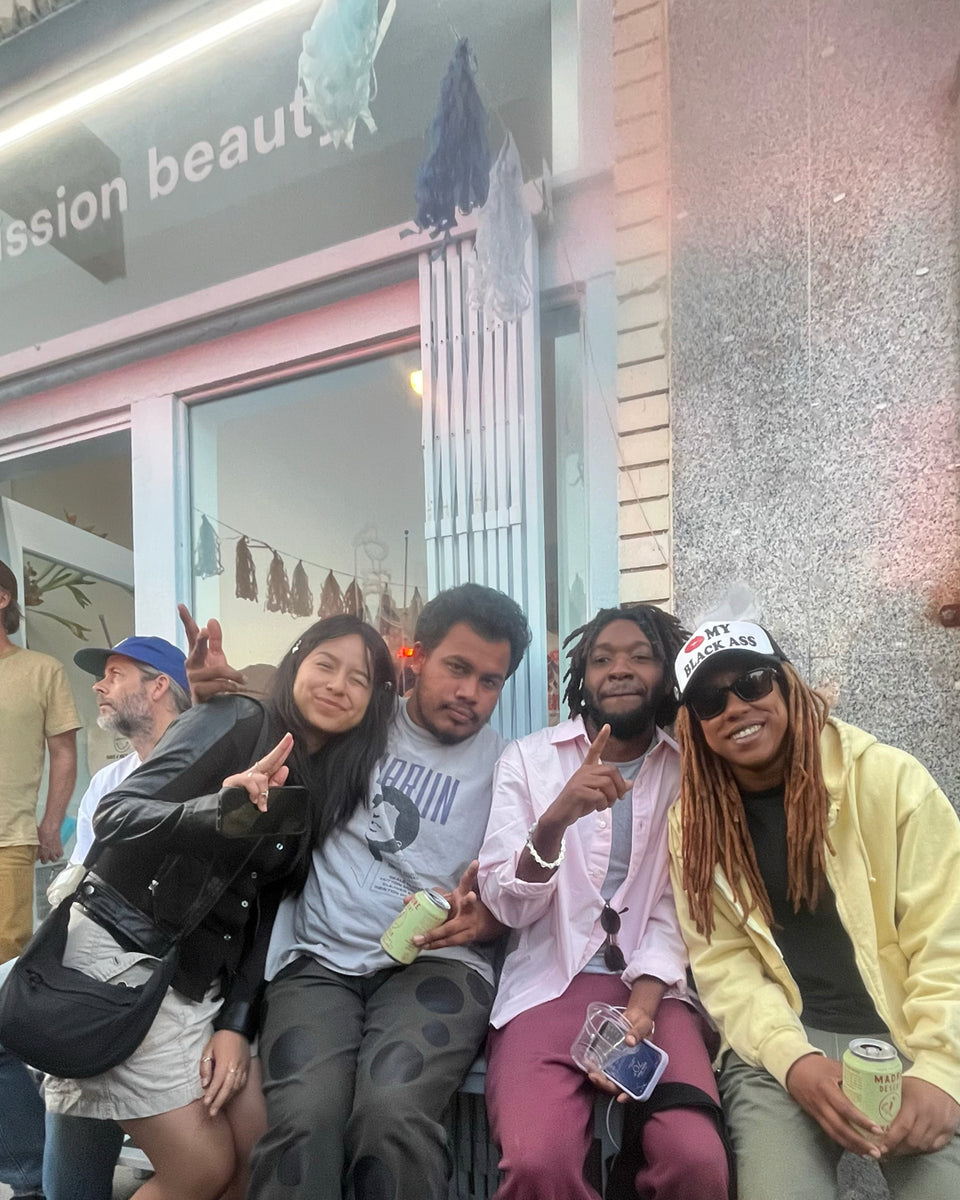 Group of people posing in front of a store with 'Mission Beauty' sign.