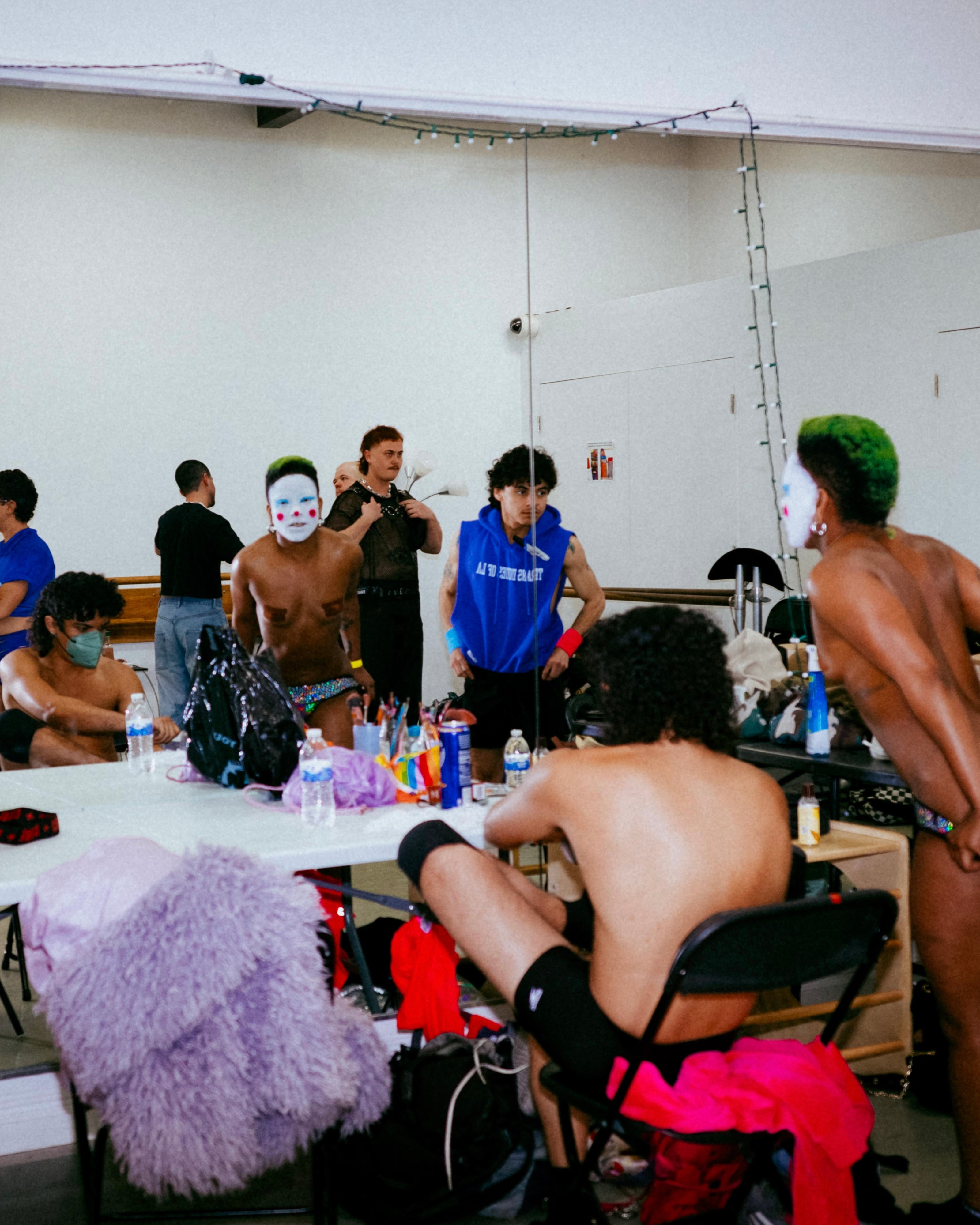 people getting ready backstage in front of a mirror