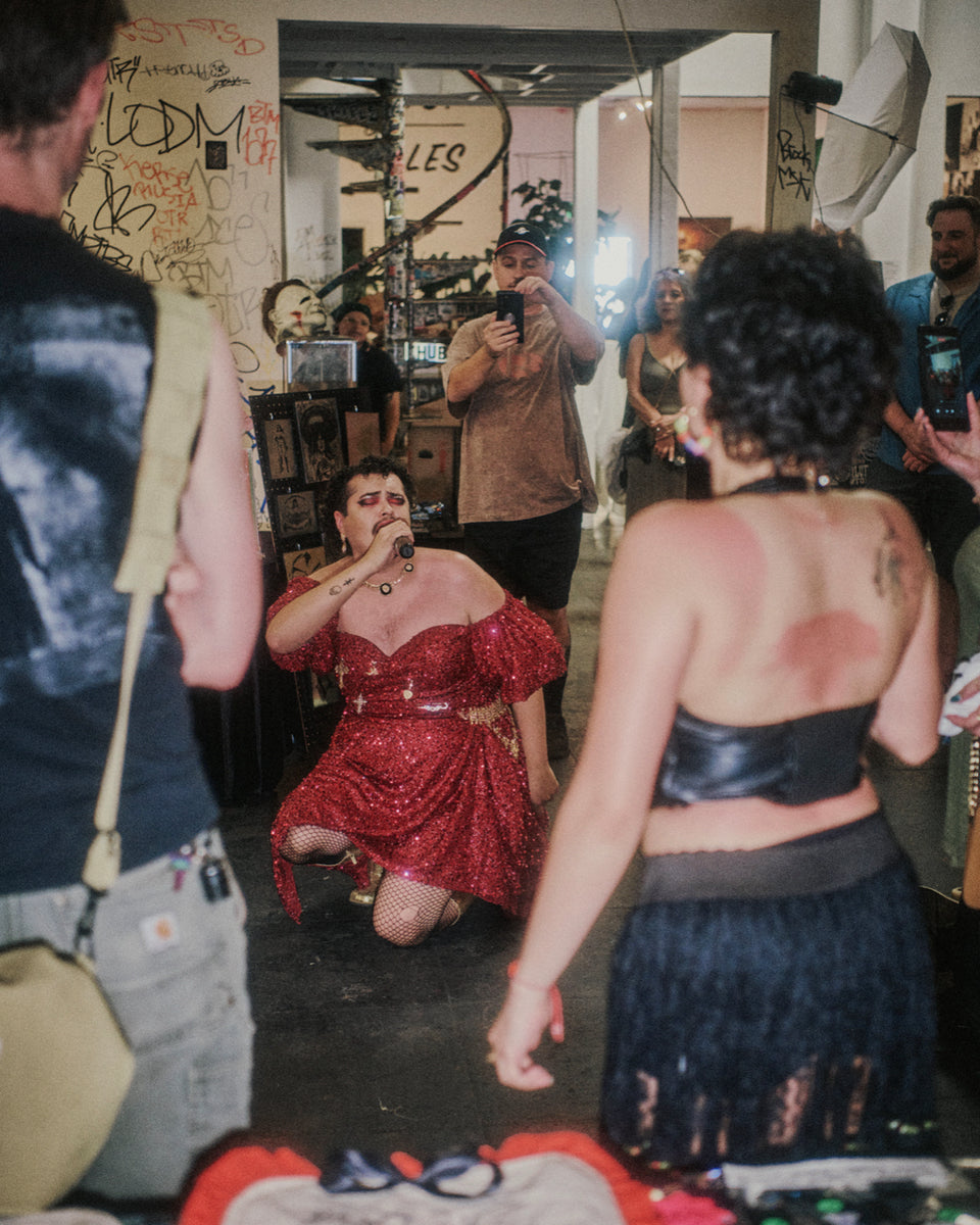 Person in a red dress surrounded by onlookers in a casual indoor setting