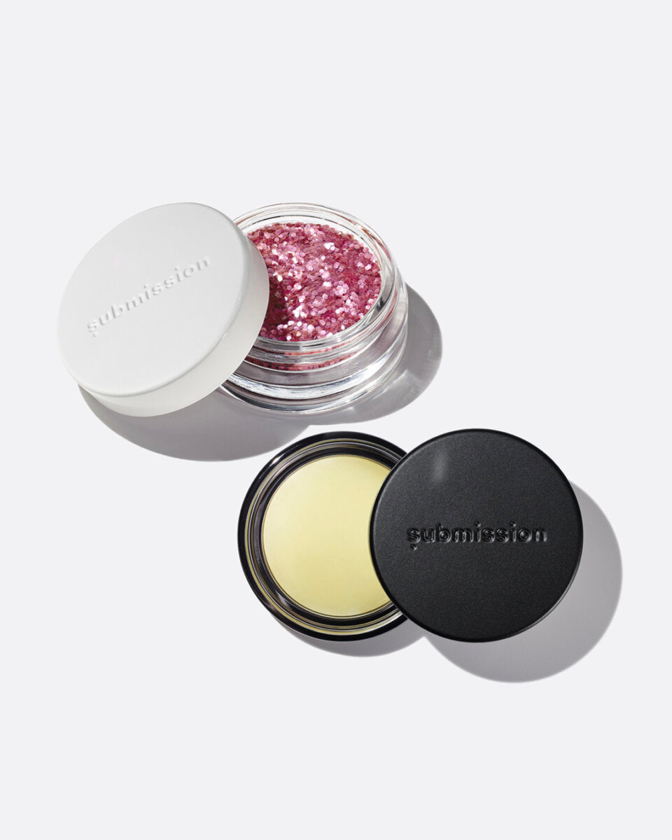 plastic-free plant-based biodegradable pink glitter in an open plastic-free container above an open container of Balm Shiny, a multifunctional plant-based balm intended for all skin types.