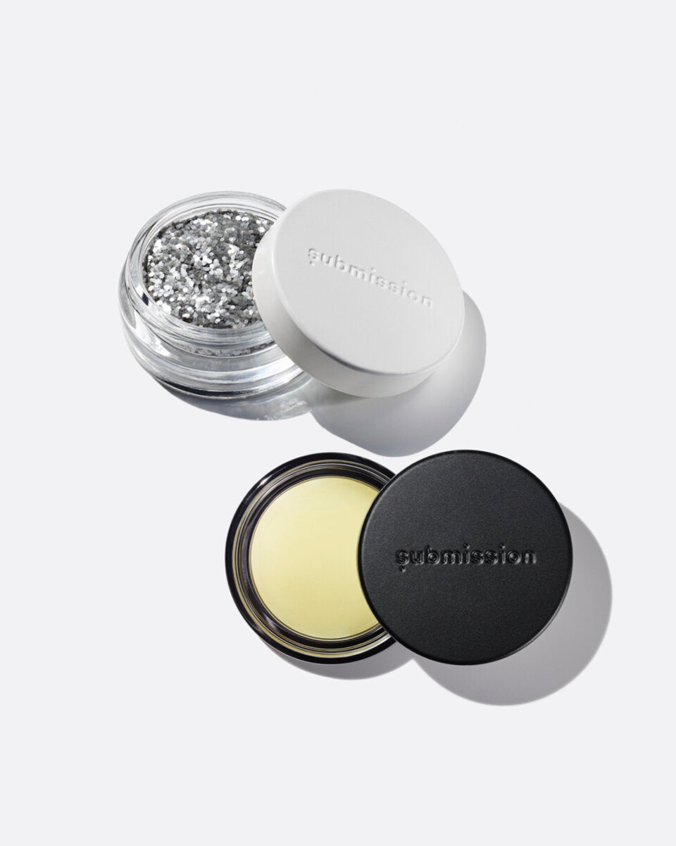 plastic-free plant-based biodegradable silver glitter in an open plastic-free container above an open container of Balm Shiny, a multifunctional plant-based balm intended for all skin types.