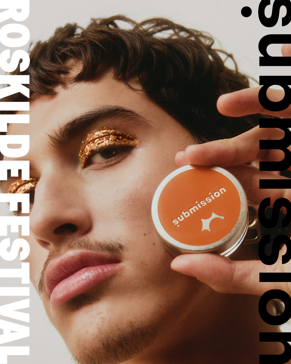Person holding a 'submission' glitter orangeproduct near their face with 'Roskilde Festival' and submission beauty text on the sides.