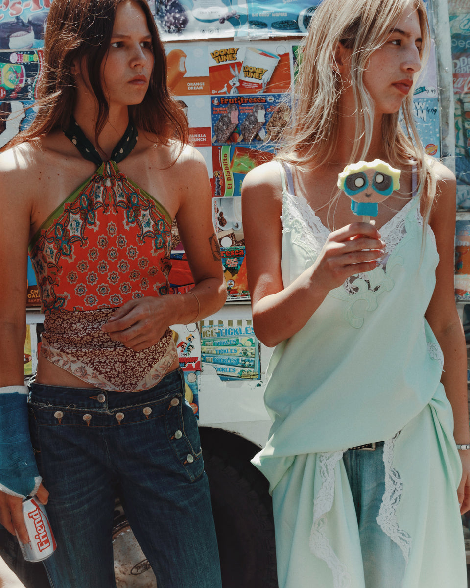 Two women standing in front of a colorful backdrop with a vintage feel.