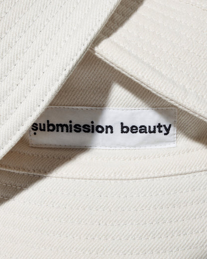 Photo showing the inside label reading submission beauty of our bucket hat, which combines recycled cotton scraps and sustainably sourced cotton