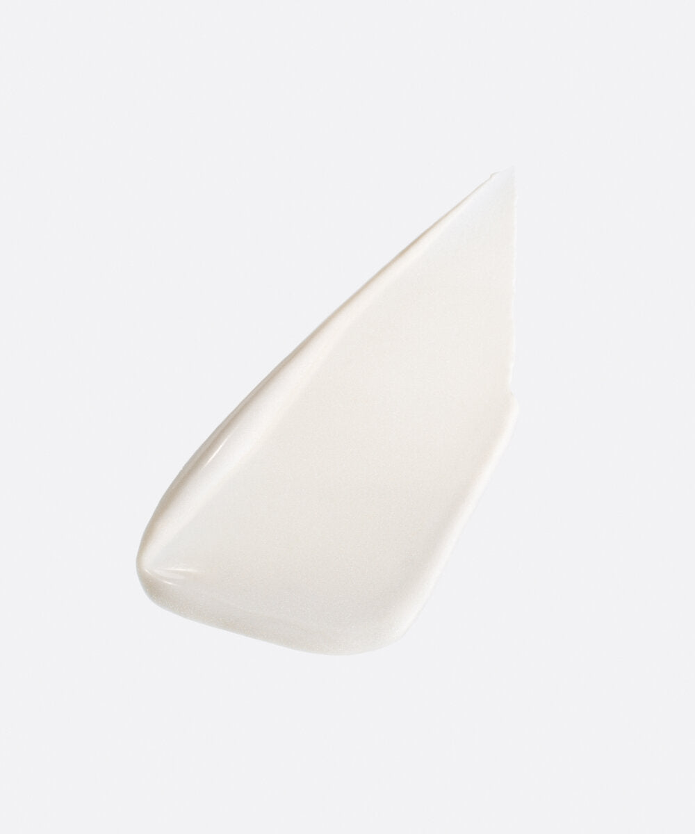 a stylized swipe of plastic-free plant-based biodegradable Highlighter Light highlighting the balm’s texture and shine and bright almost white color