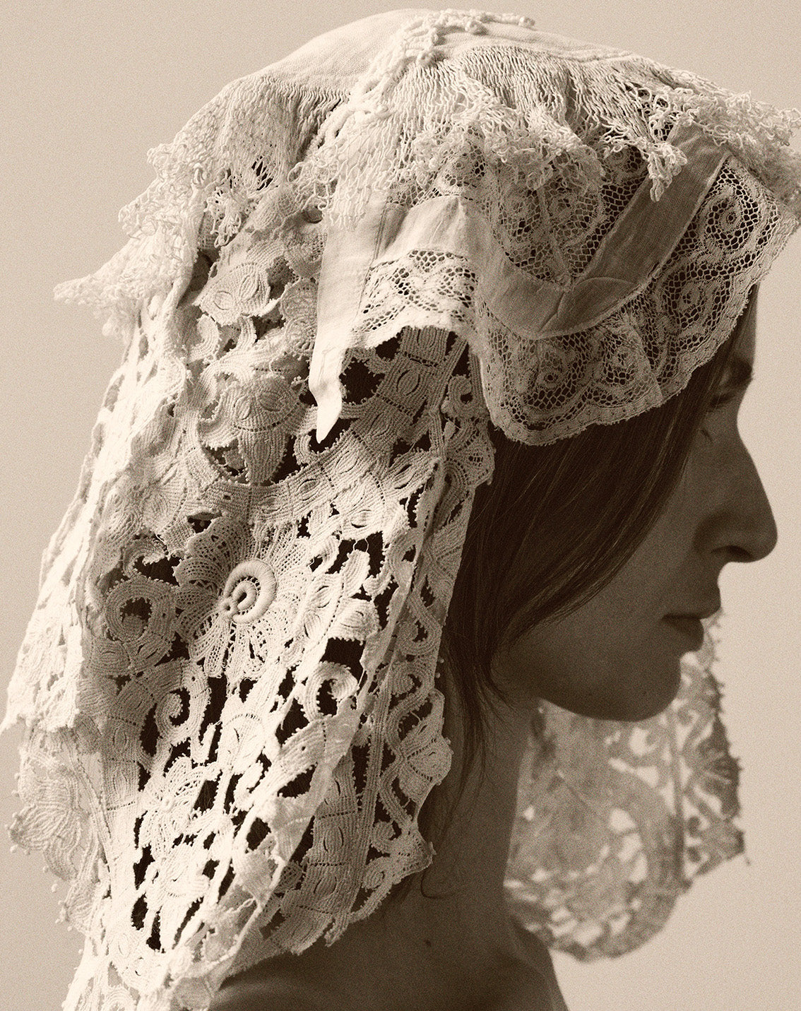 Person wearing a lace headscarf in sepia tone