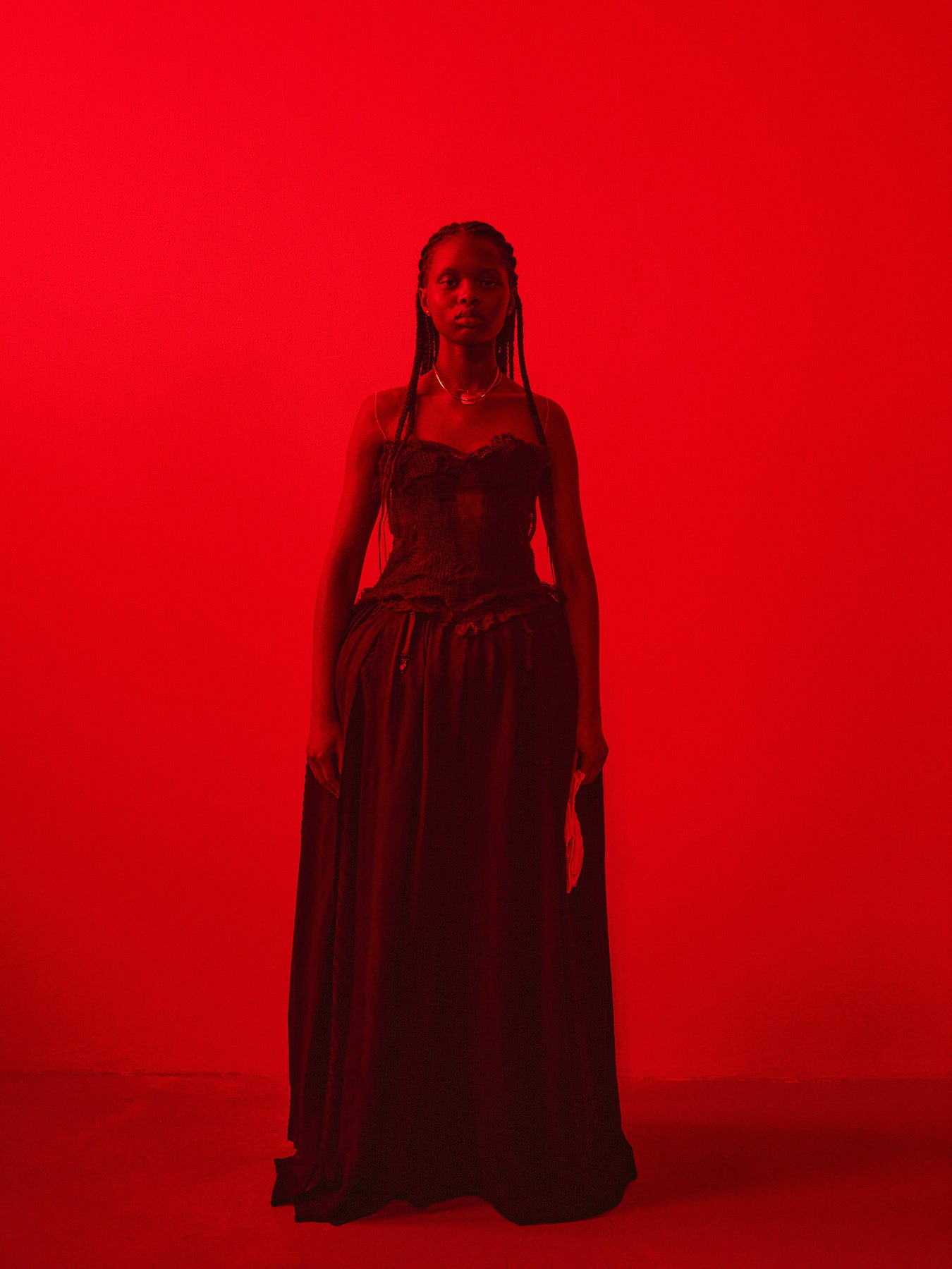 Woman in a dark red dress against a bright red background