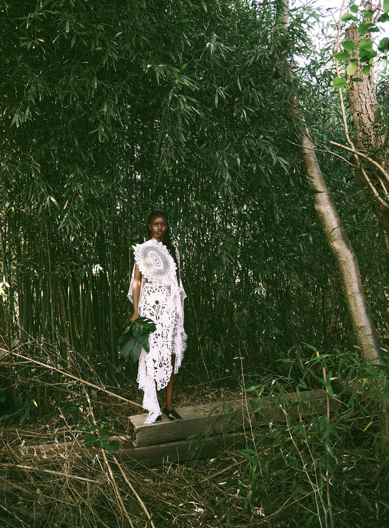 Person in a white dress standing in a forest setting