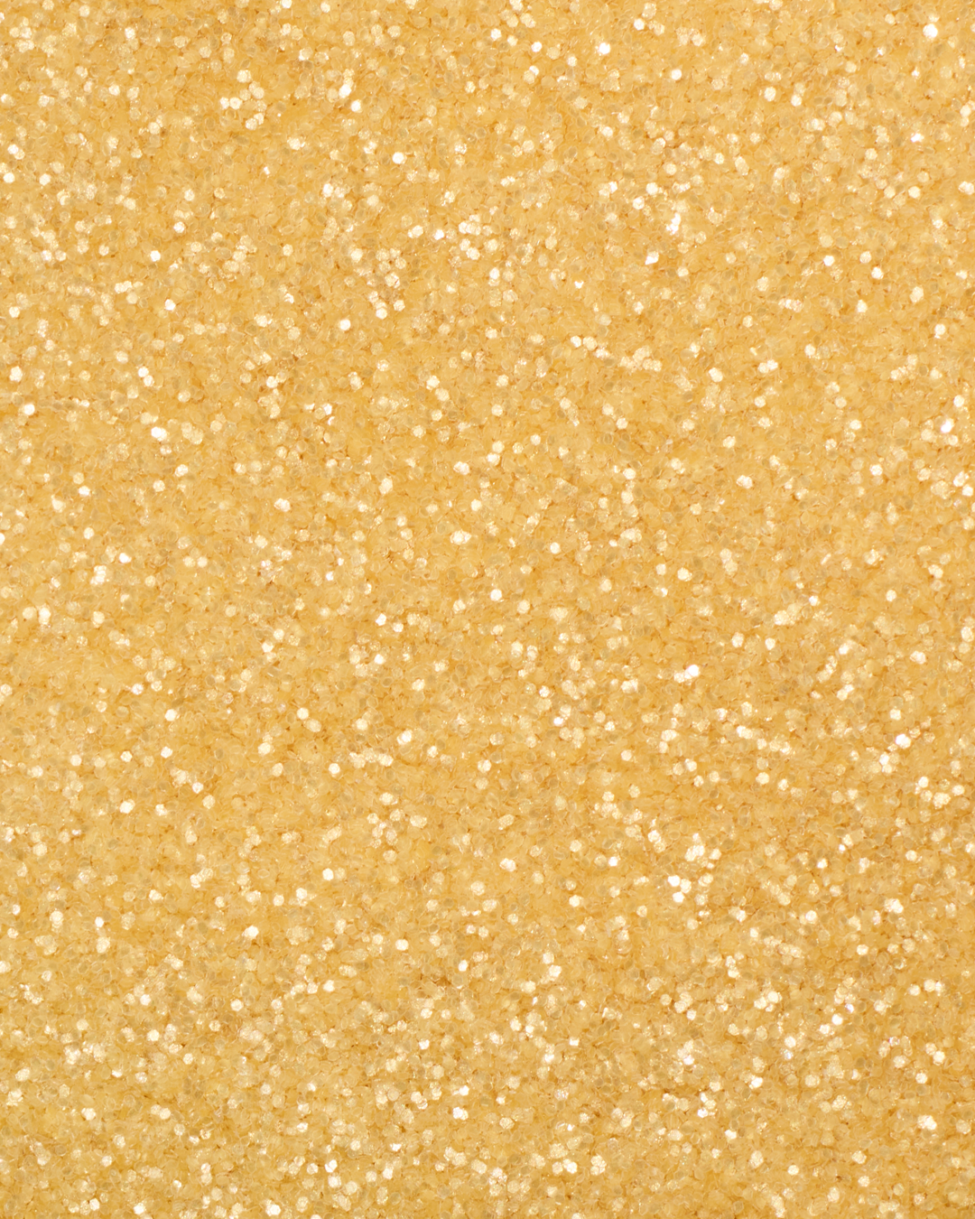 a square, full-bleed overhead view of plastic-free plant-based biodegradable gold glitter flakes highlighting the glitter’s texture and varied shades of gold