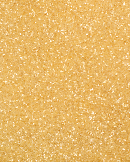 a square, full-bleed overhead view of plastic-free plant-based biodegradable gold glitter flakes highlighting the glitter’s texture and varied shades of gold