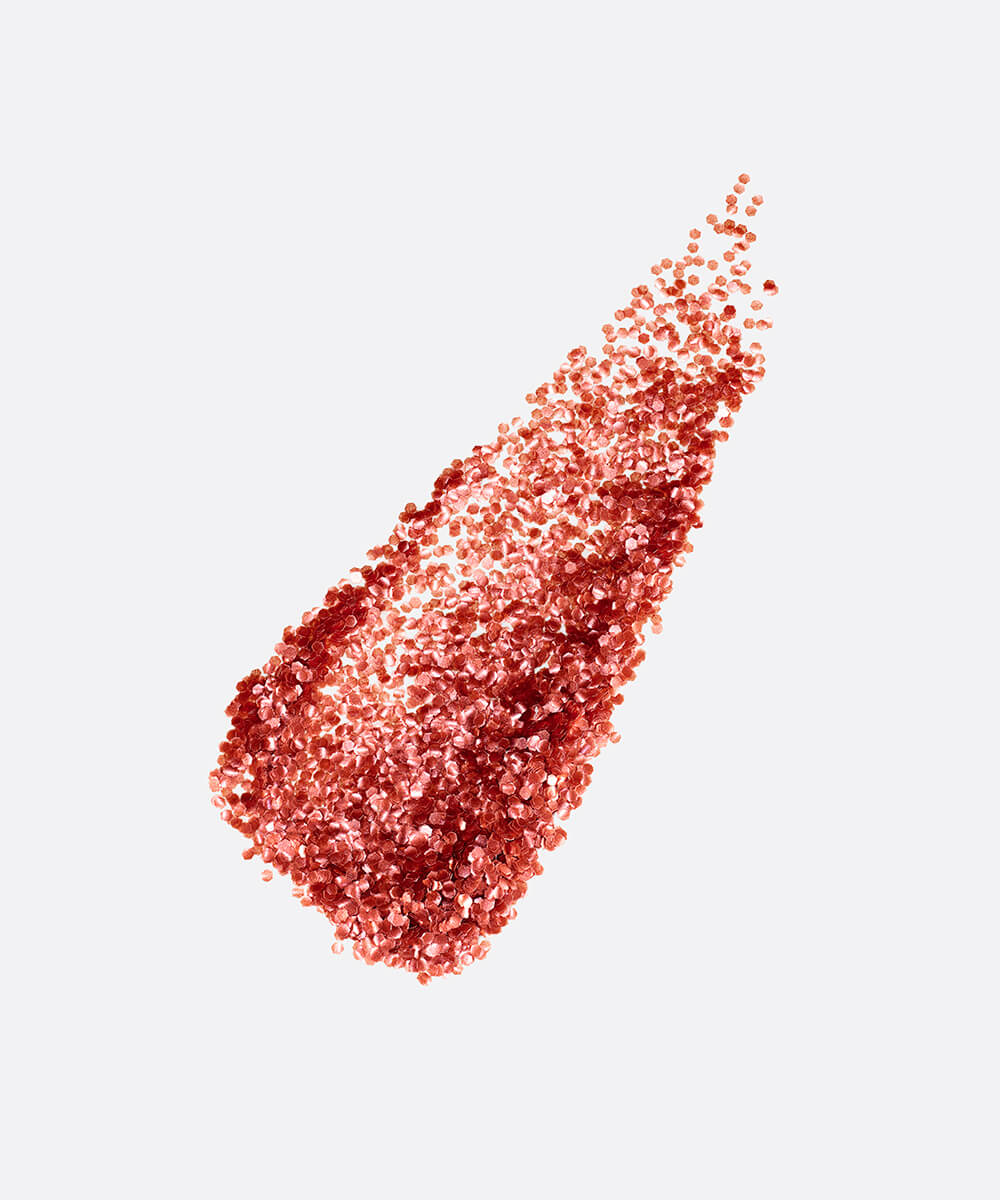 a stylized swipe of plastic-free plant-based biodegradable red glitter highlighting the glitter’s texture and varied shades of red